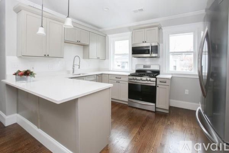 A modern kitchen with white cabinets and appliances.