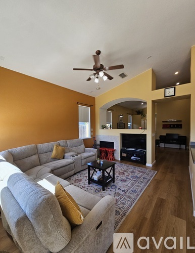 A living room with a grey sofa and a black coffee table.