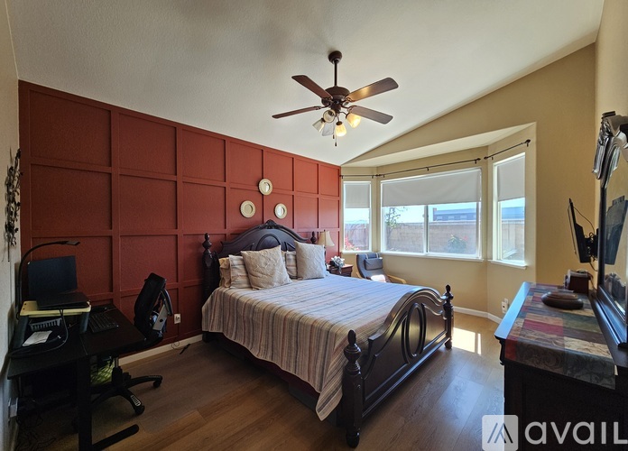 A bedroom with a bed, desk, and chair.