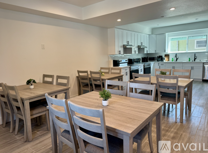 A kitchen with a dining table and chairs.