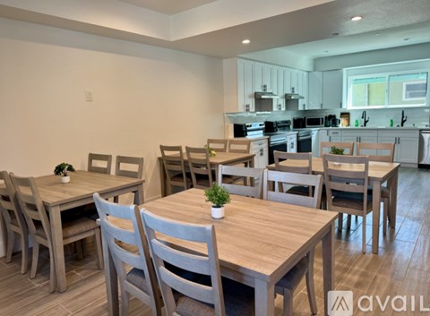 A kitchen with a dining table and chairs.