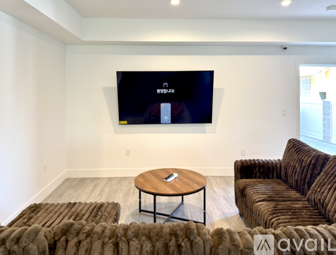 A living room with a flat screen TV mounted on the wall.