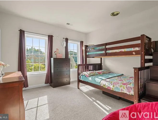 A bedroom with a bunk bed and a dresser.