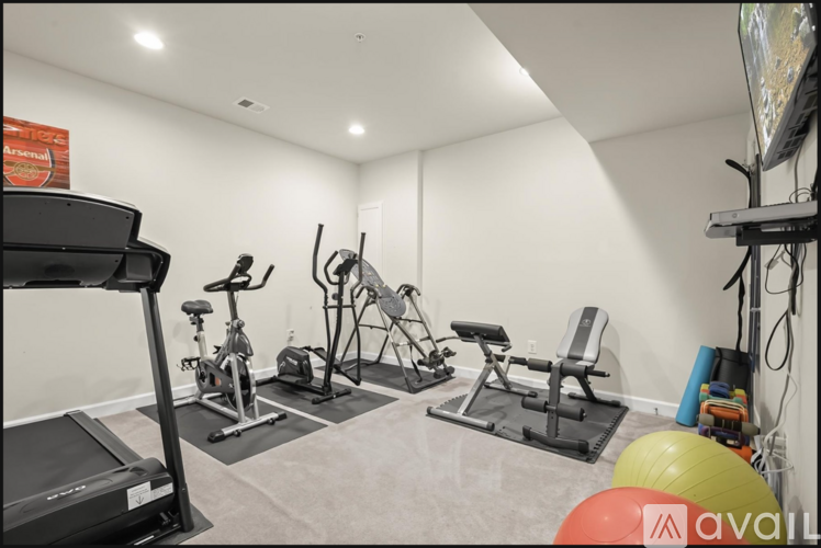 A home gym with a treadmill, exercise bike, and other equipment.