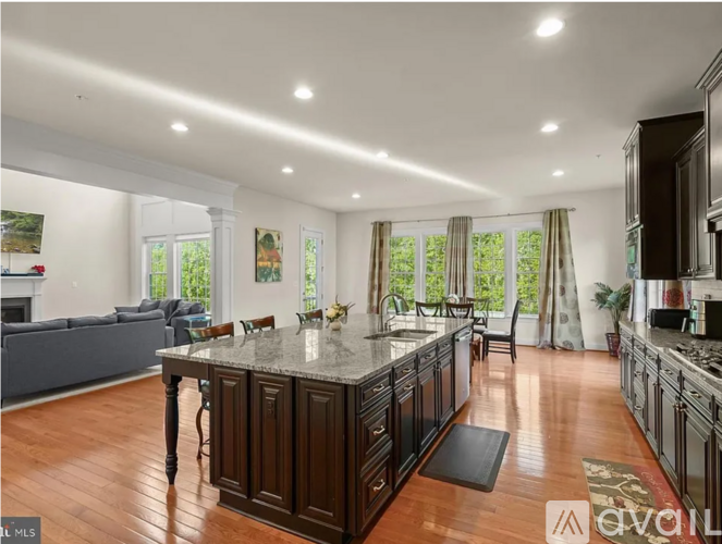 A spacious kitchen with dark wood cabinets and a central island.