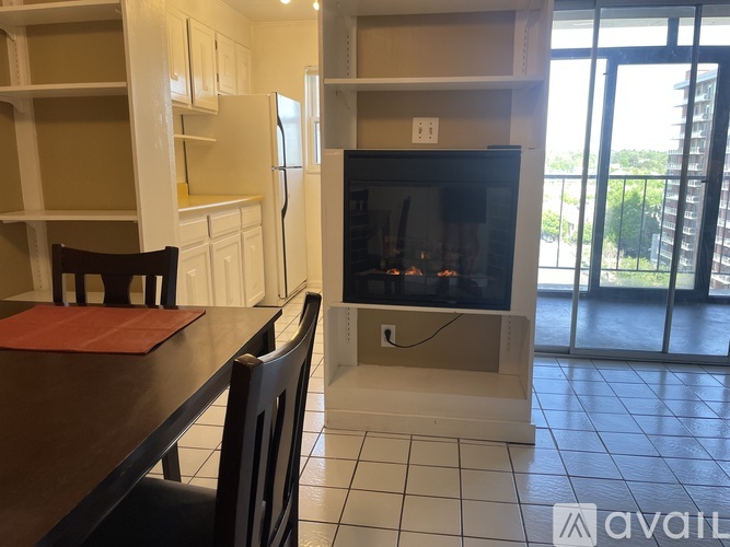 A kitchen with a table and chairs and a television.