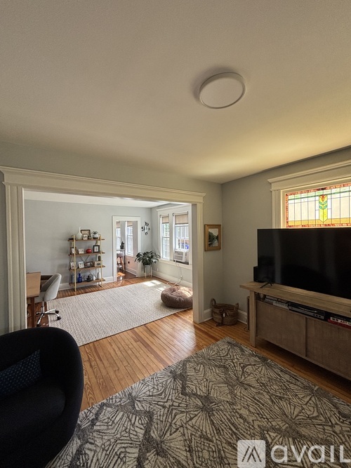 A living room with a television, a chair, and a rug.