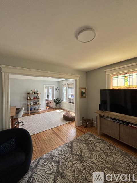 A living room with a television, a chair, and a rug.