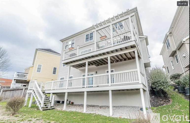 A two-story house with a balcony and stairs leading to the second floor.