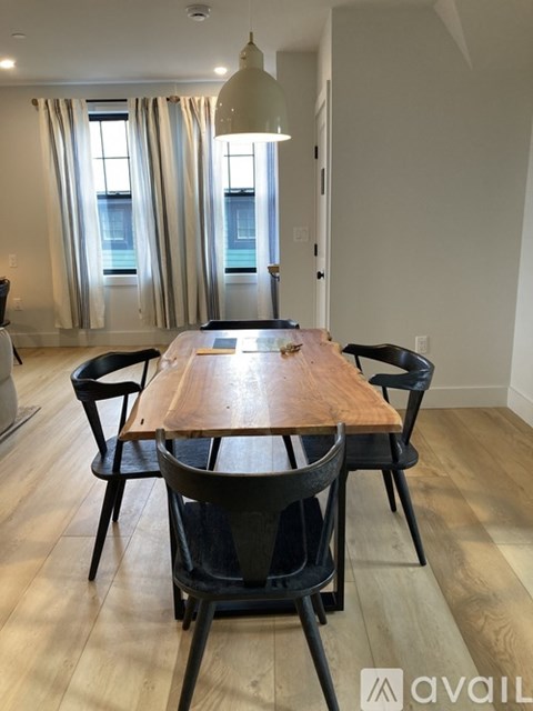 A dining room with a wooden table and chairs.