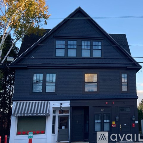 A black building with a white awning that says "coffee breakfast lunch".