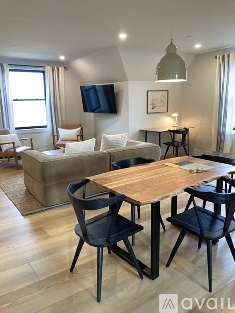 A modern living room with a wooden table and chairs.