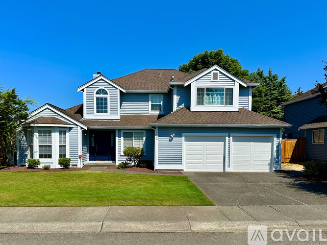 A two-story house with a garage and a driveway.