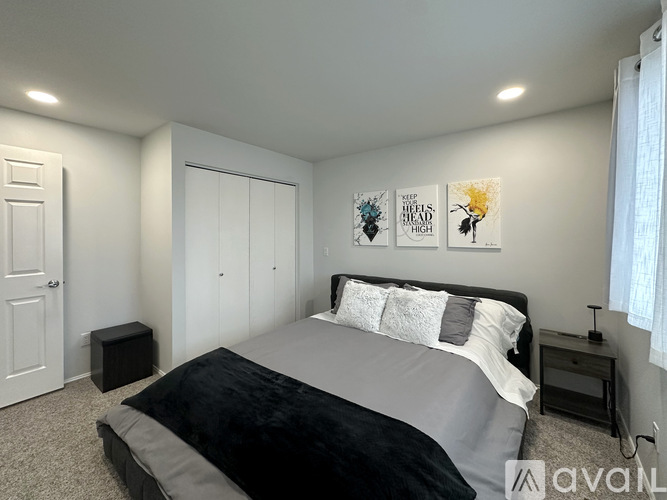 A bedroom with a large bed and two posters on the wall.