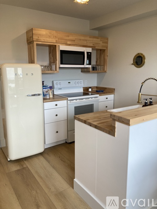A kitchen with a white fridge and wooden cabinets.