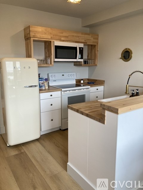 A kitchen with a white fridge and wooden cabinets.
