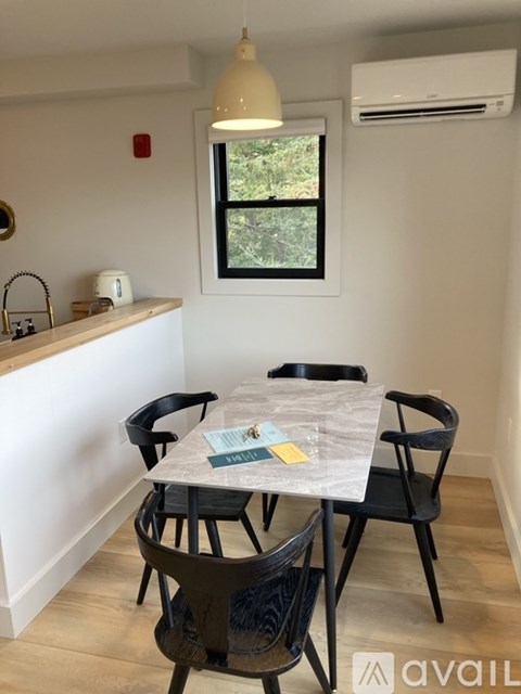 A dining room with a table and chairs.