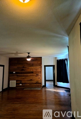 A room with wooden walls and a ceiling fan.