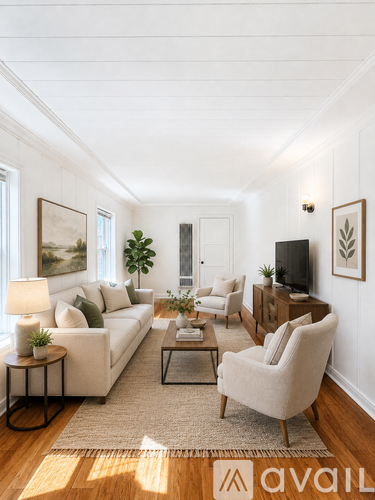 A living room with a white couch, a chair, a coffee table, and a television.