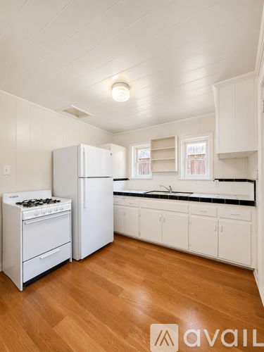 A kitchen with white appliances and cabinets.