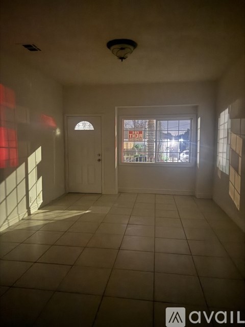 A room with a white door and tiled floor.