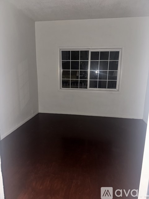 A room with a window and wooden floor.