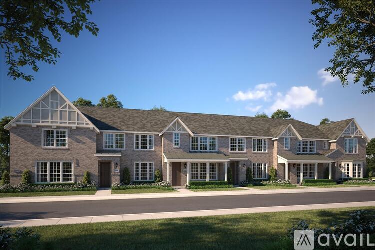 A large, modern house with a large front yard and a driveway.