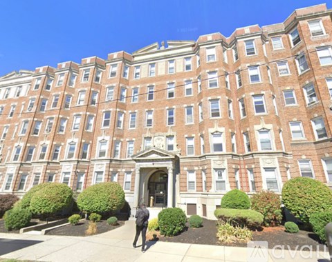 A person is walking towards a large red brick building.
