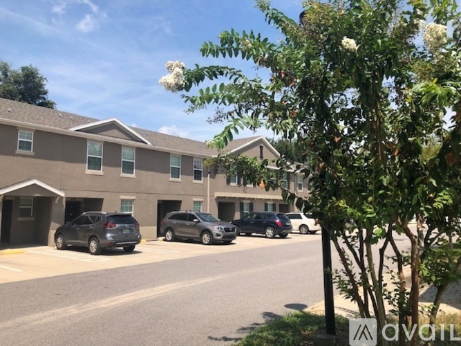 A parking lot in front of a building with cars parked.