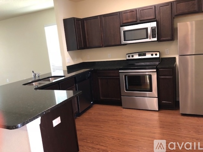 A kitchen with dark brown cabinets and stainless steel appliances.