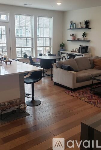A living room with a couch, chair, and a table with a television on it.