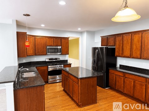 A kitchen with wooden cabinets and black countertops.