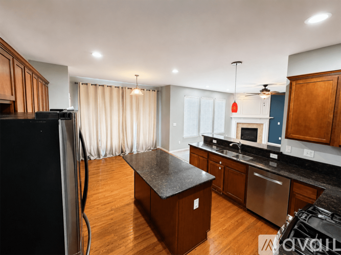 A kitchen with wooden cabinets and a black countertop.
