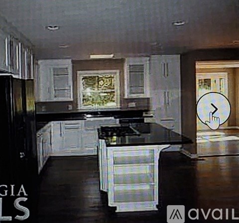 A kitchen with black appliances and white cabinets.