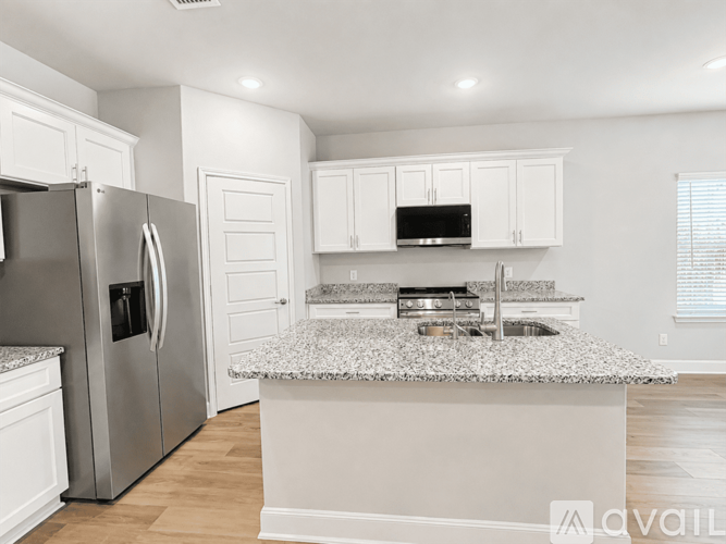 A kitchen with a granite countertop and stainless steel appliances.