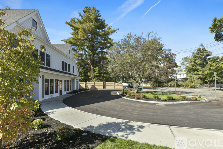 A white building with a driveway in front of it.