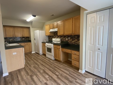A kitchen with wooden cabinets and a white refrigerator.