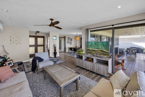 A modern living room with a wooden coffee table and a ceiling fan.