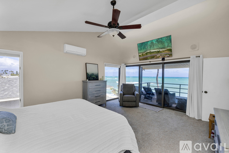 A bedroom with a large bed and a view of the ocean.