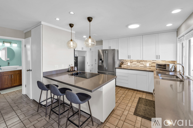 A modern kitchen with white cabinets and a large island.