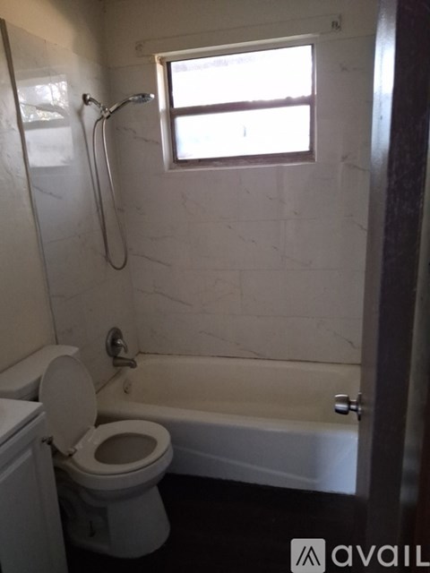 A white toilet is next to a bathtub in a bathroom.