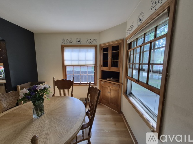 A dining room with a round wooden table and chairs.