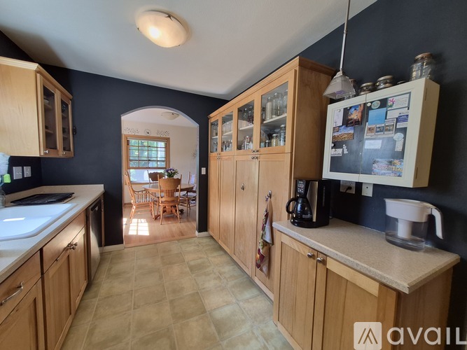 A kitchen with wooden cabinets and a tiled floor.