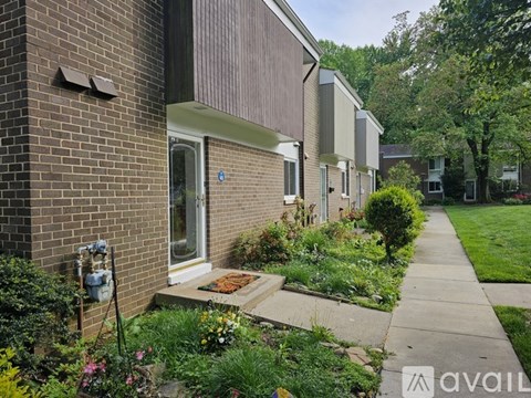A brick house with a small garden in front.