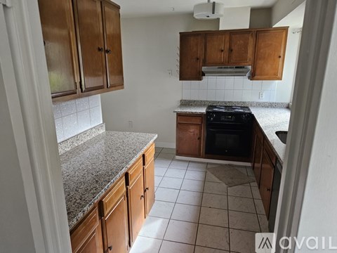 A kitchen with wooden cabinets and a granite countertop.