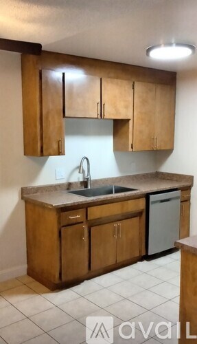 A kitchen with wooden cabinets and a sink.
