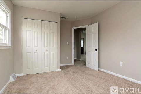 A room with a carpeted floor and a white door.
