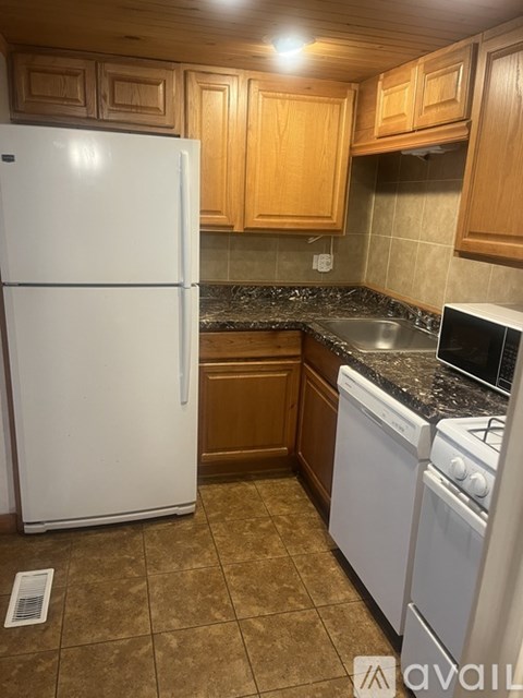 A kitchen with a white refrigerator and white stove.