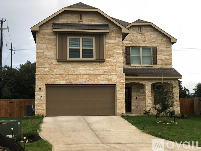 A two-story house with a garage and a driveway.