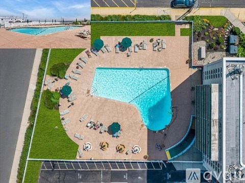 An aerial view of a swimming pool surrounded by lounge chairs and umbrellas.